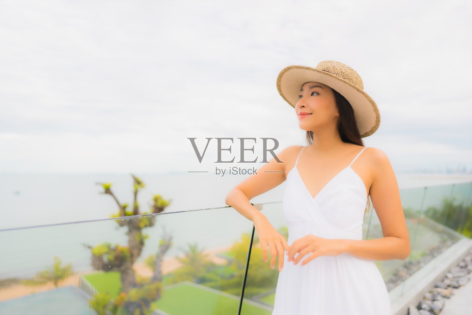 美丽的年轻亚洲女人幸福的微笑围绕着海景阳台照片摄影图片