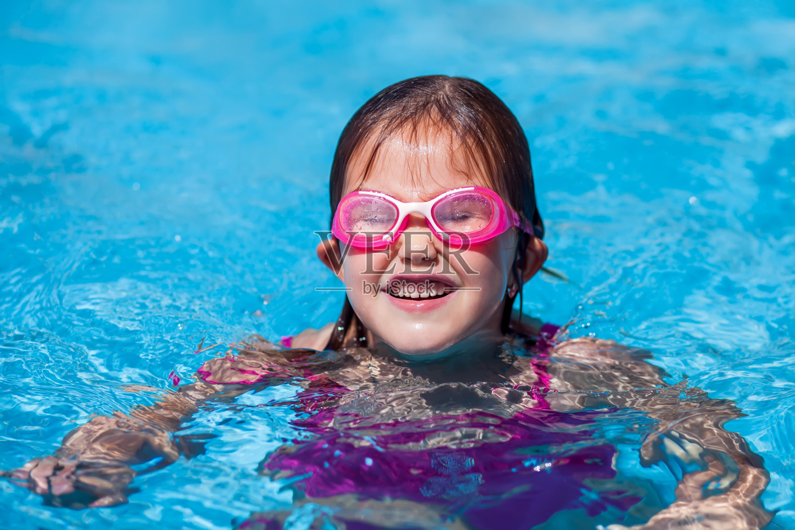 小女孩在游泳池里玩。童年、夏季和假期的概念照片摄影图片