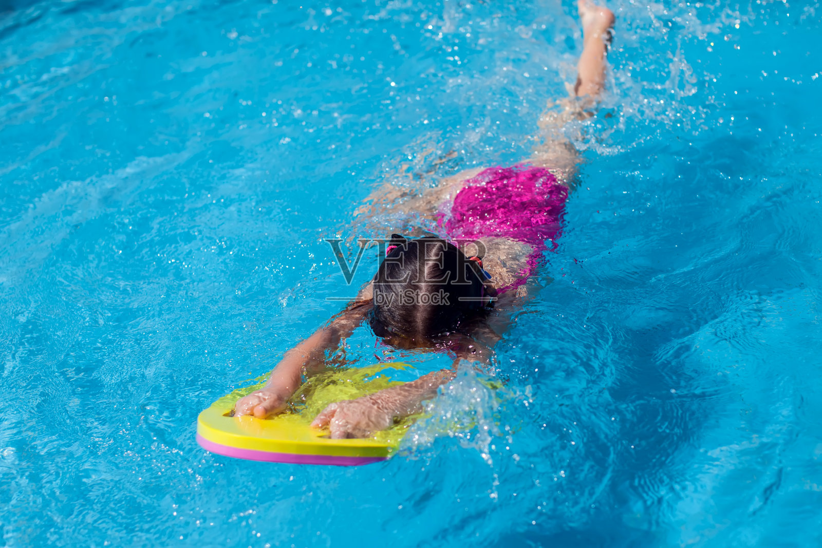 小女孩在游泳池里玩。童年、夏季和假期的概念照片摄影图片