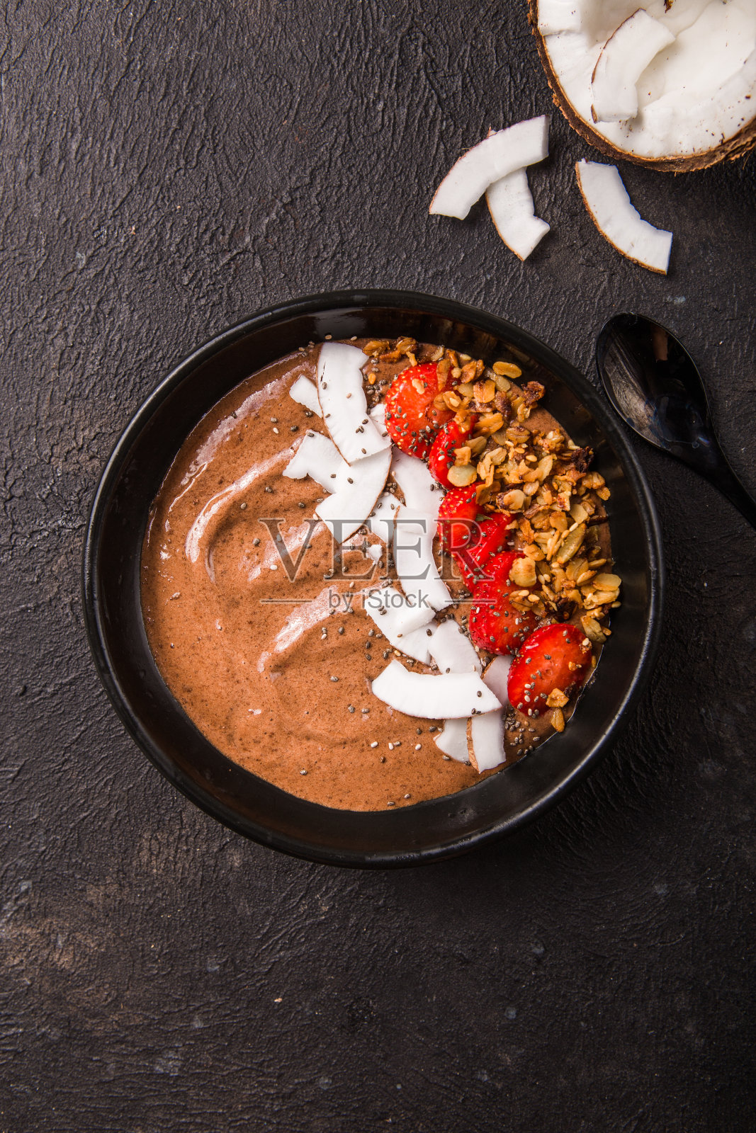 健康的早餐碗。巧克力香蕉冰沙碗,椰片,格兰诺拉麦片,草莓。俯视图,平躺,头顶照片摄影图片