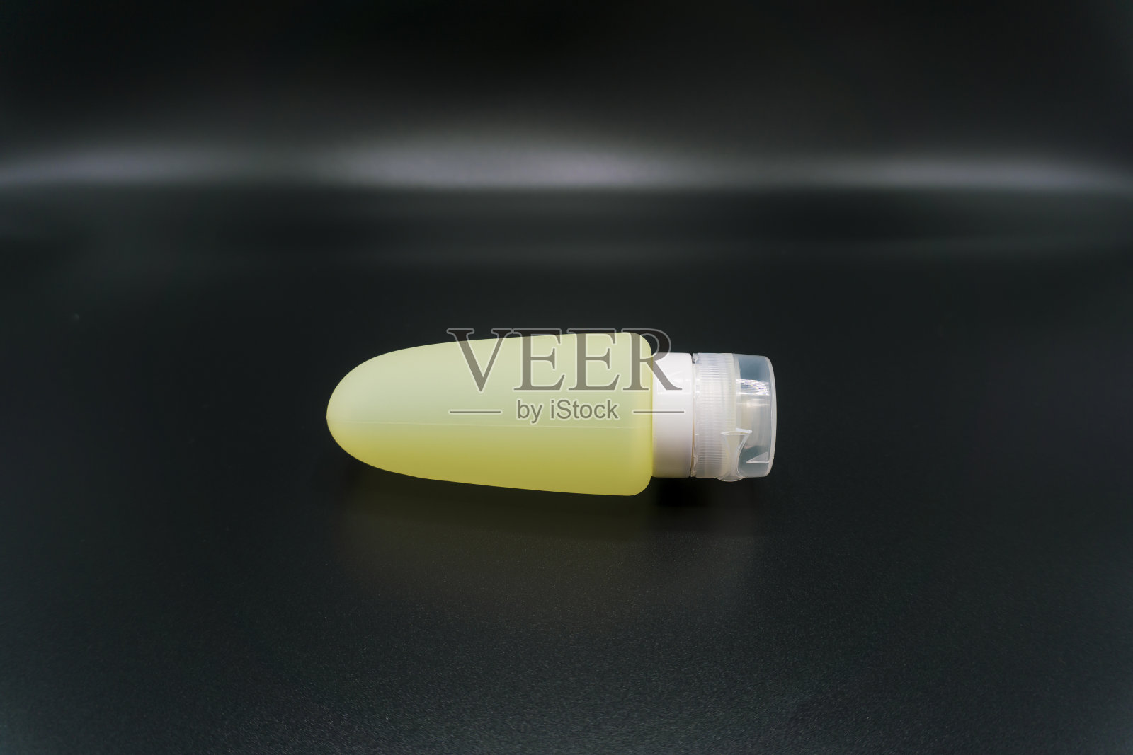 黄色化妆硅胶管的沐浴乳或洗发水在深色的背景照片摄影图片