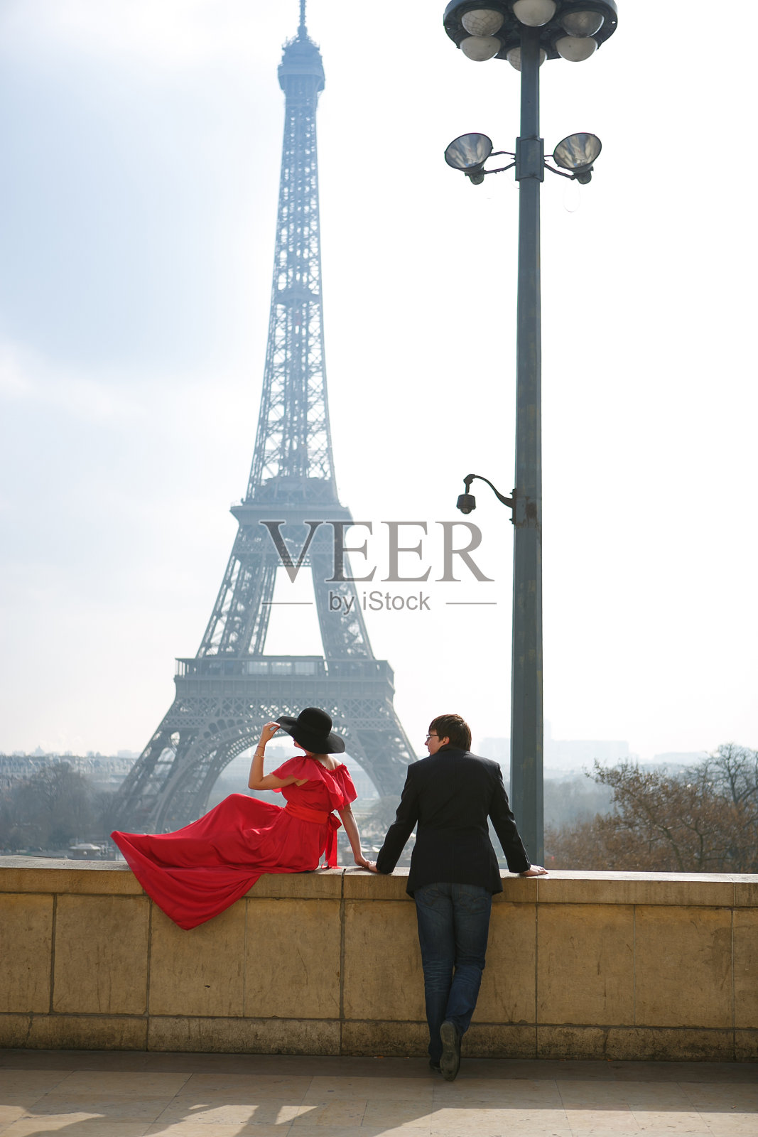 在巴黎的埃菲尔铁塔上,穿着红色衣服、戴着帽子的男男女女。法国的象征。照片摄影图片