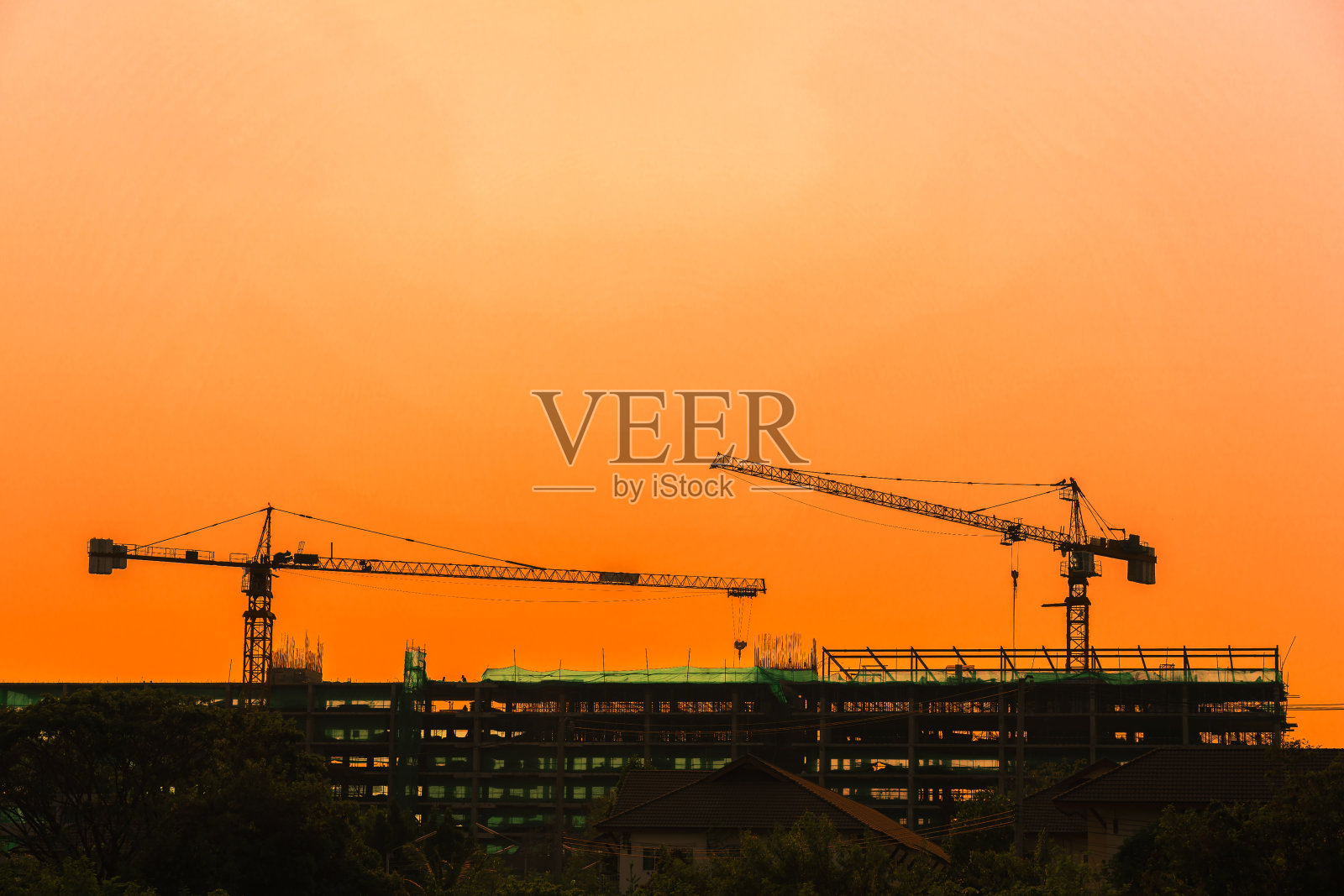 夕阳背景下的塔吊和建筑剪影照片摄影图片