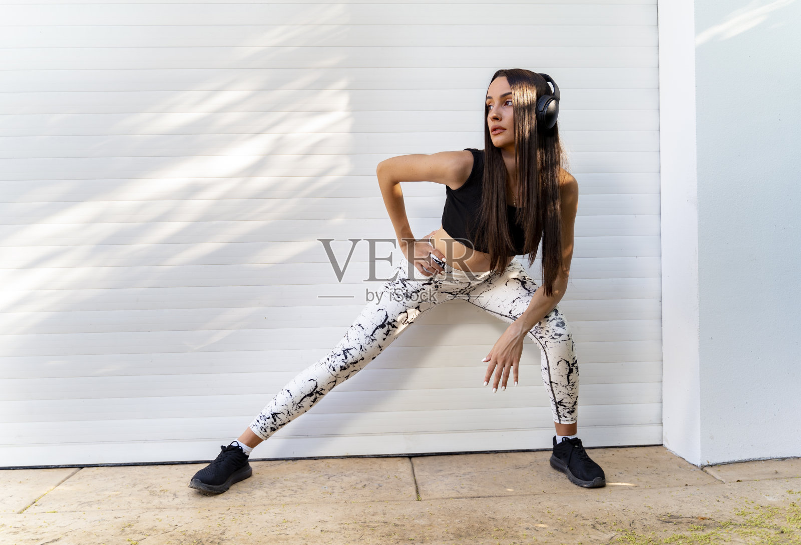 迷人的城市健身女孩与耳机摆姿势照片摄影图片