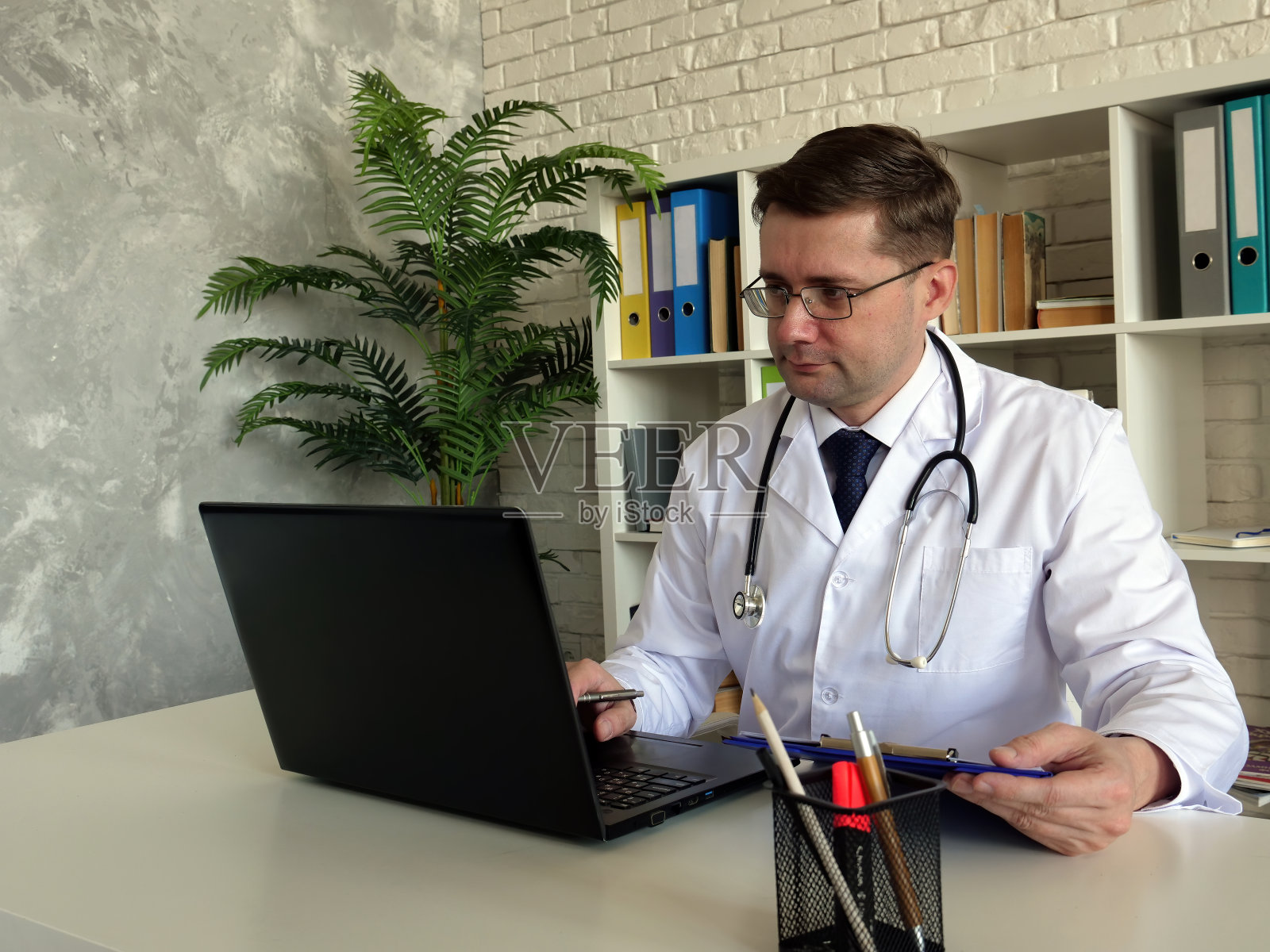 远程医疗的概念。医生使用笔记本电脑工作。照片摄影图片