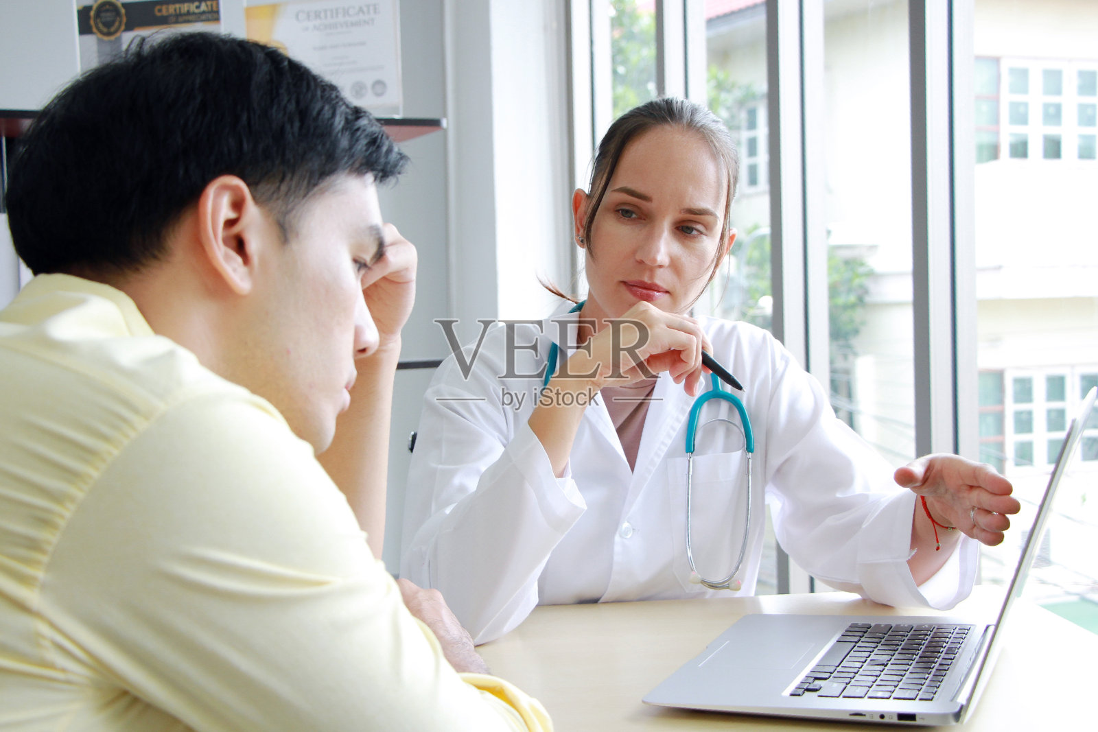 白人女精神科医生用笔记本电脑在网站上咨询和研究亚洲男性的治疗方法,探讨重度抑郁症患者和医疗保健理念照片摄影图片