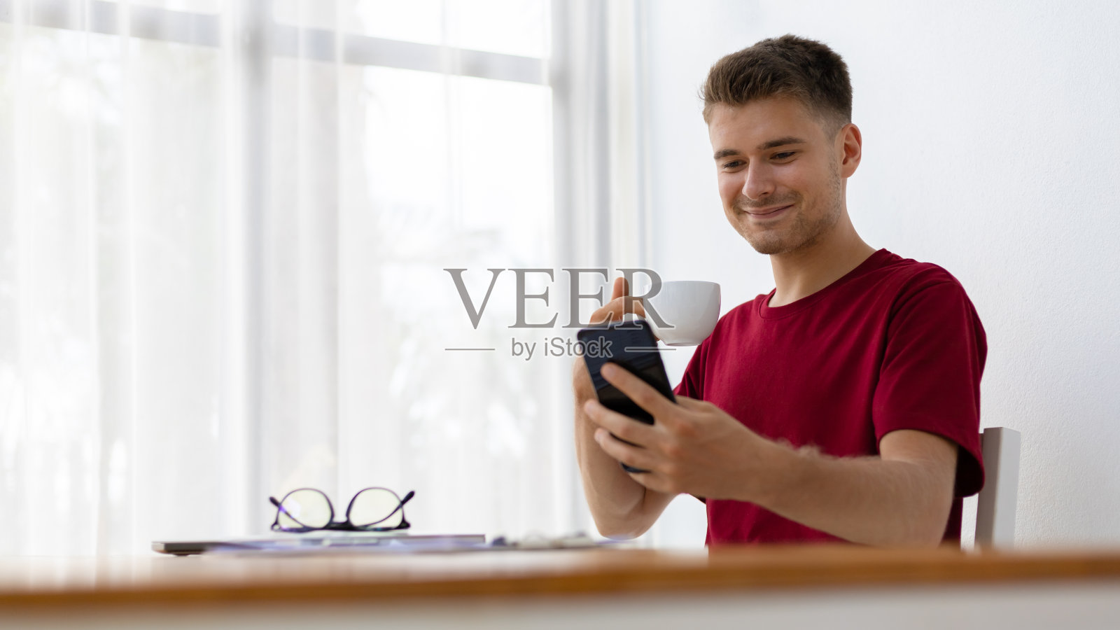 喝咖啡用智能手机的幸福男人照片摄影图片