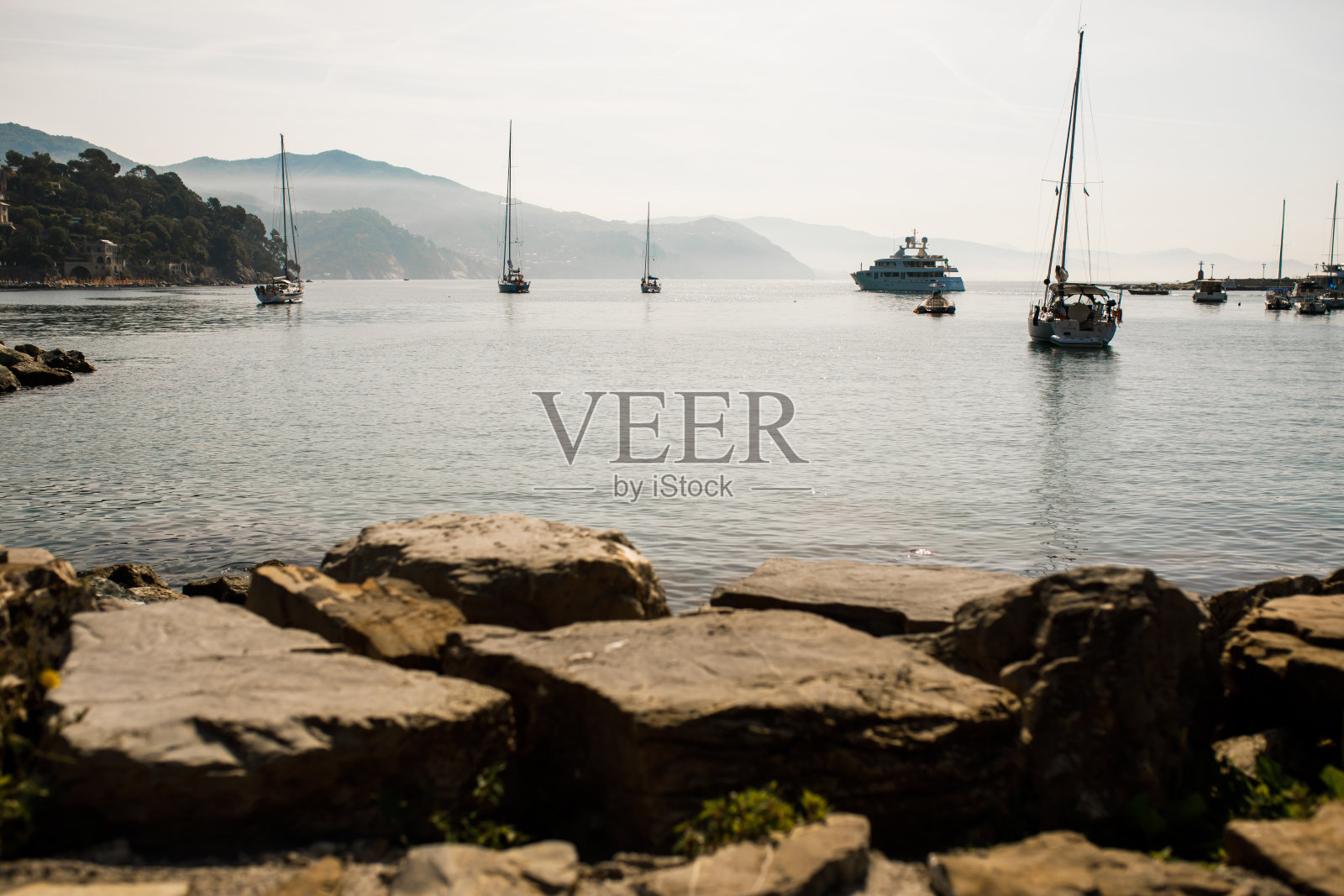 游艇停泊在海湾里。在山的背景。照片摄影图片