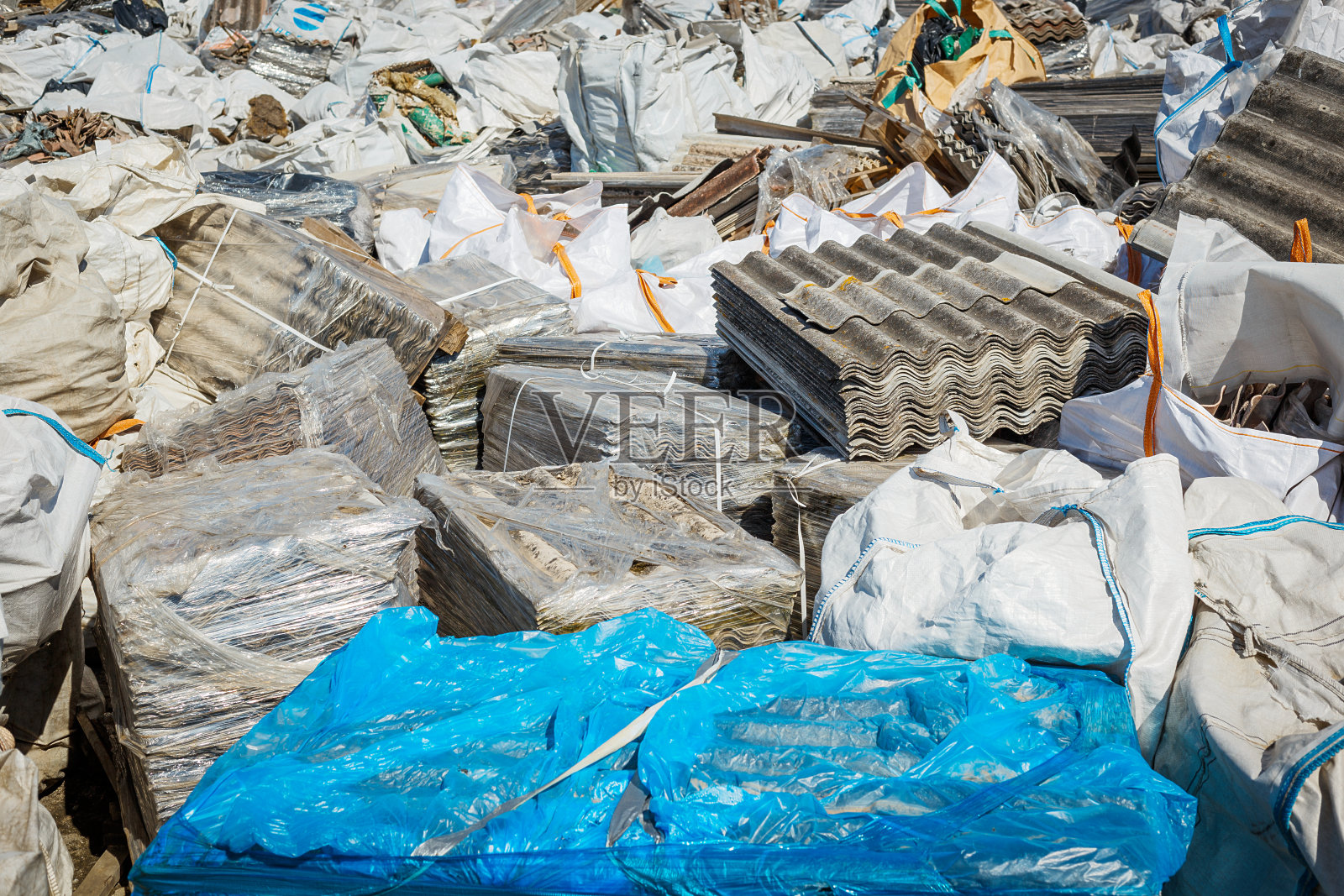 石棉垃圾填埋场。屋顶覆盖材料与石棉纤维。照片摄影图片