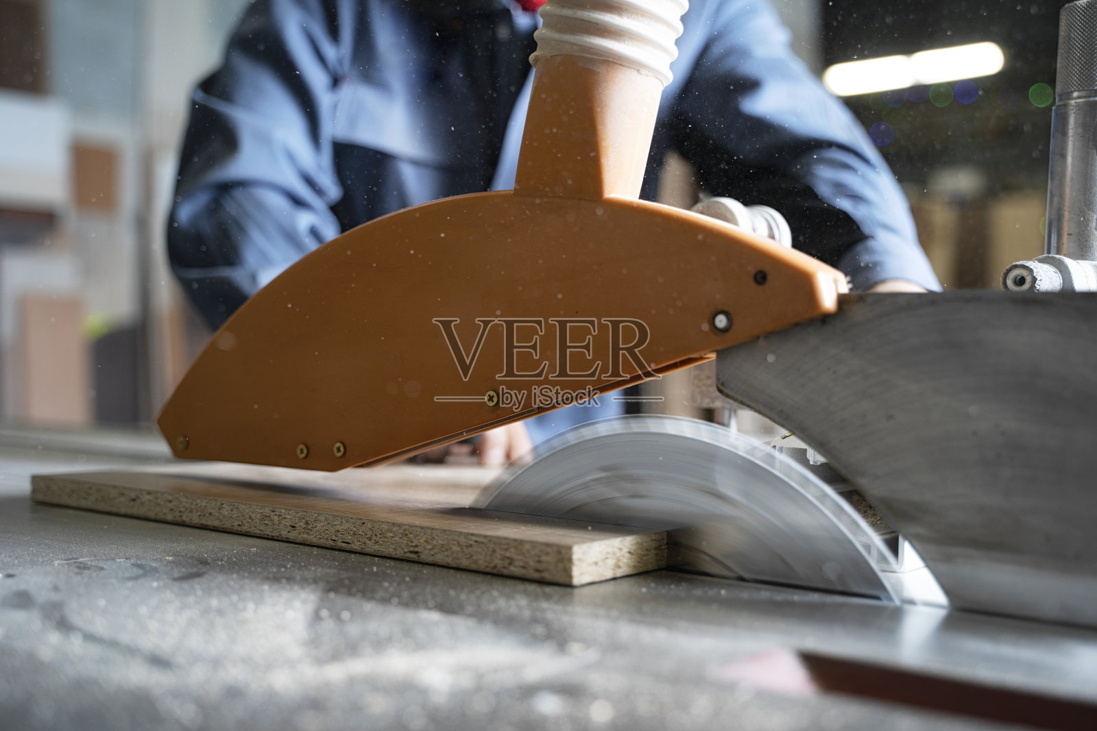 用圆锯用电动工具切割木板的木匠照片摄影图片