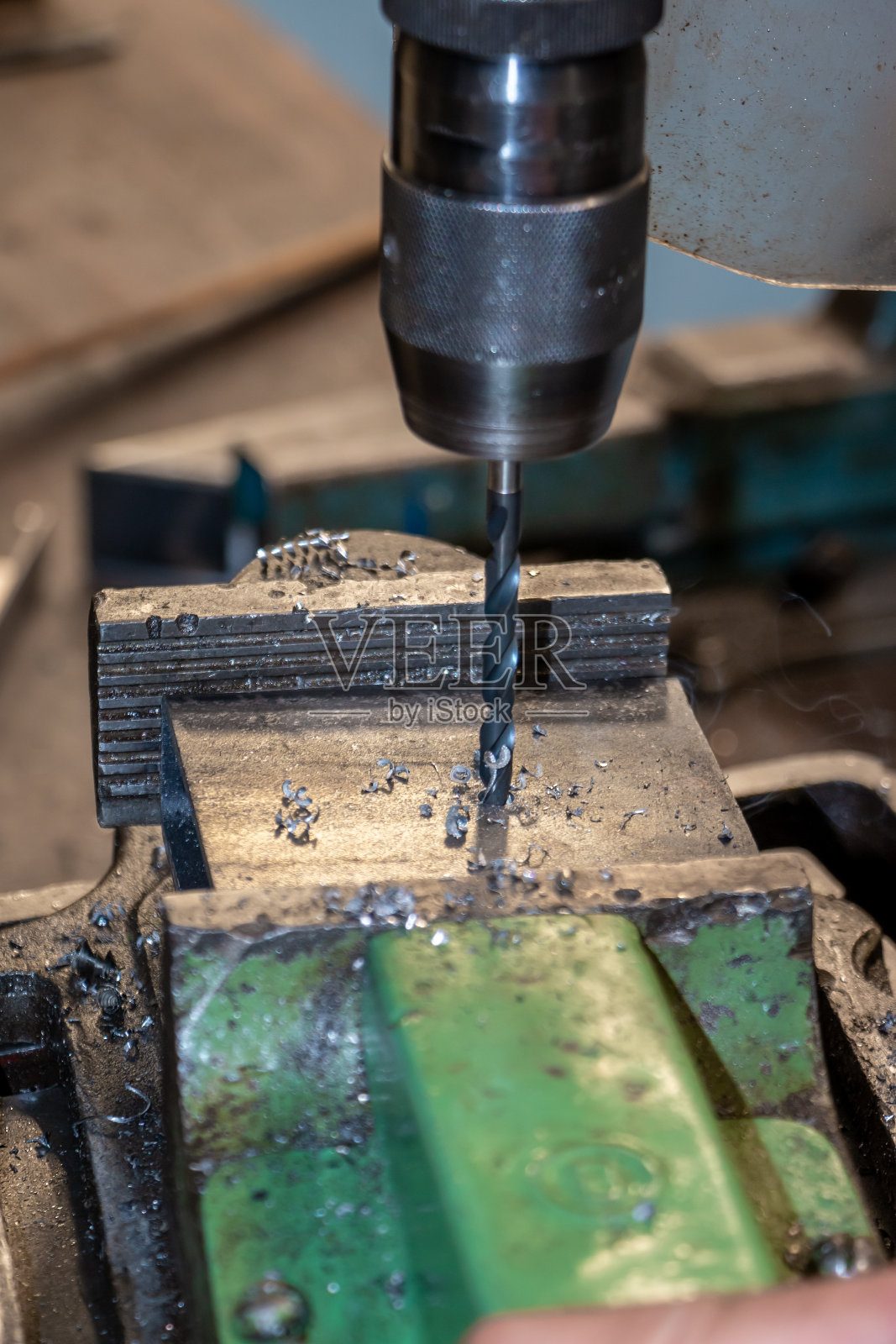 在车间工作,用钻头打孔照片摄影图片