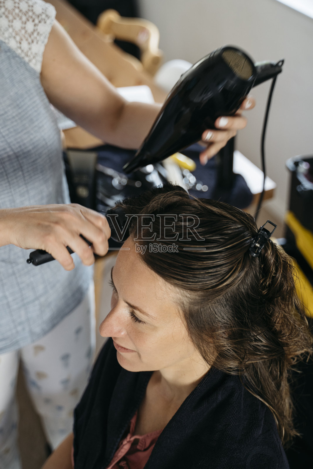 移动发型师在家为一名年轻女子理发照片摄影图片