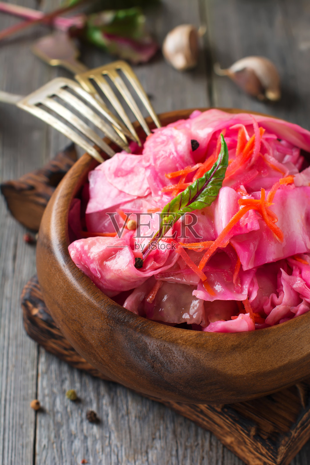 酸菜、甜菜和胡萝卜放在一个竹碗里,背景是旧的木头。乡村风格。有选择性的重点。照片摄影图片