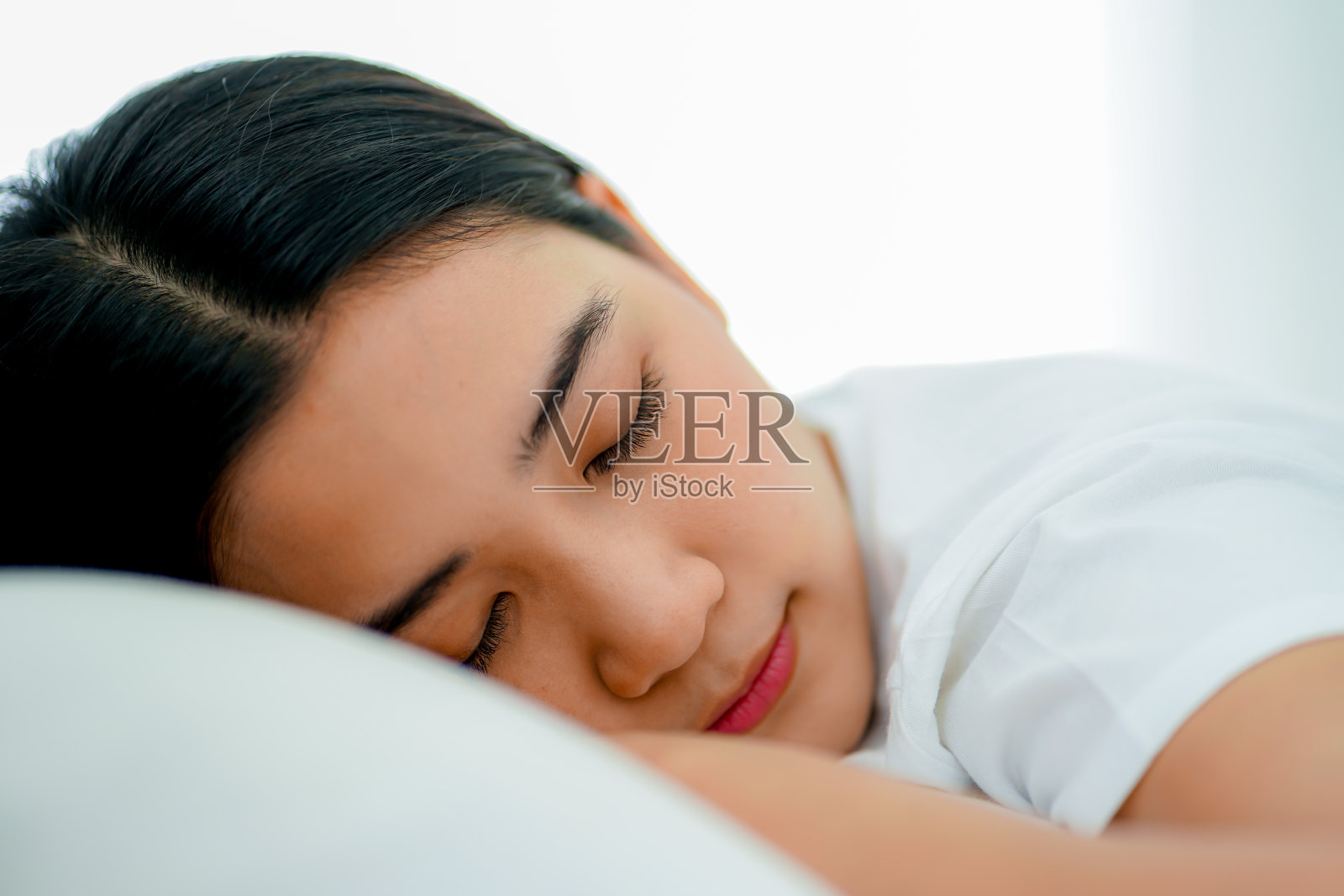 年轻的亚洲女子躺在床下的干净的白色被子在假日工作期间从家里社交距离照片摄影图片