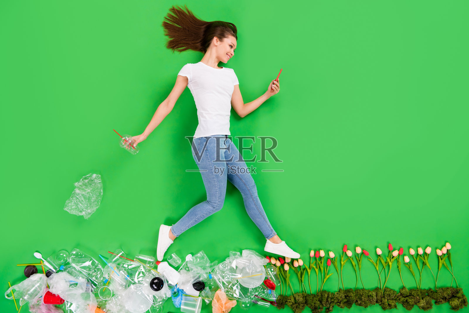 全长高角度平躺照片不负责任的市民女士扔塑料制品乱扔街道污染步骤鲜花电话成瘾孤立的绿色背景照片摄影图片