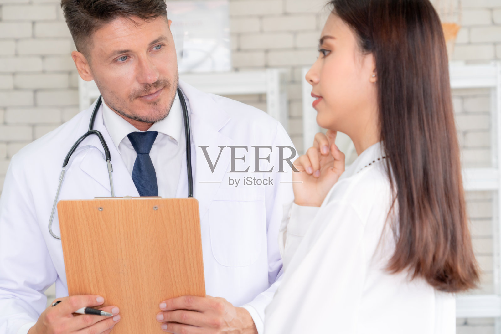 身穿专业制服的医生在医院为病人检查照片摄影图片