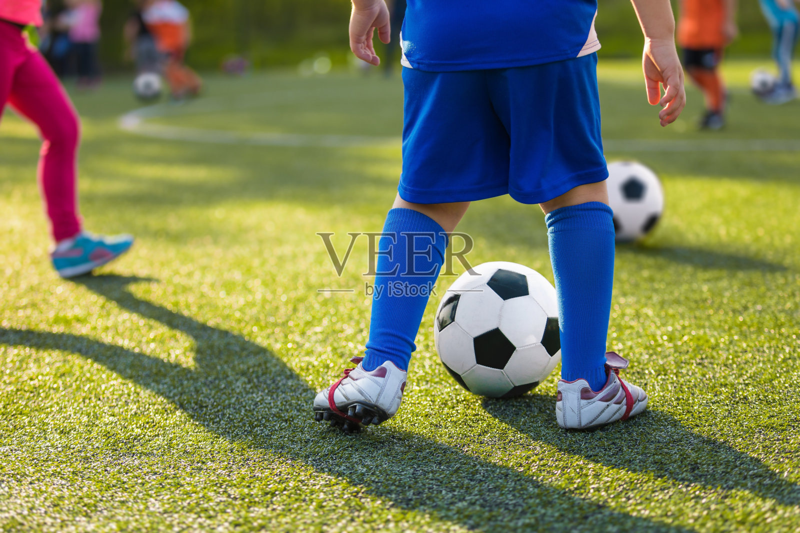 儿童足球控制训练。儿童足球控制练习。年轻的足球运动员与教练在运动草地上练习照片摄影图片