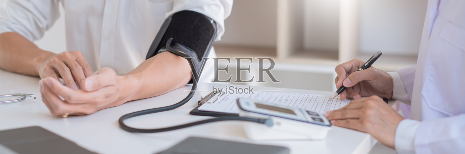 医生用血压计或血压计测量病人的血压,检查心跳并谈论医院的医疗保健照片摄影图片