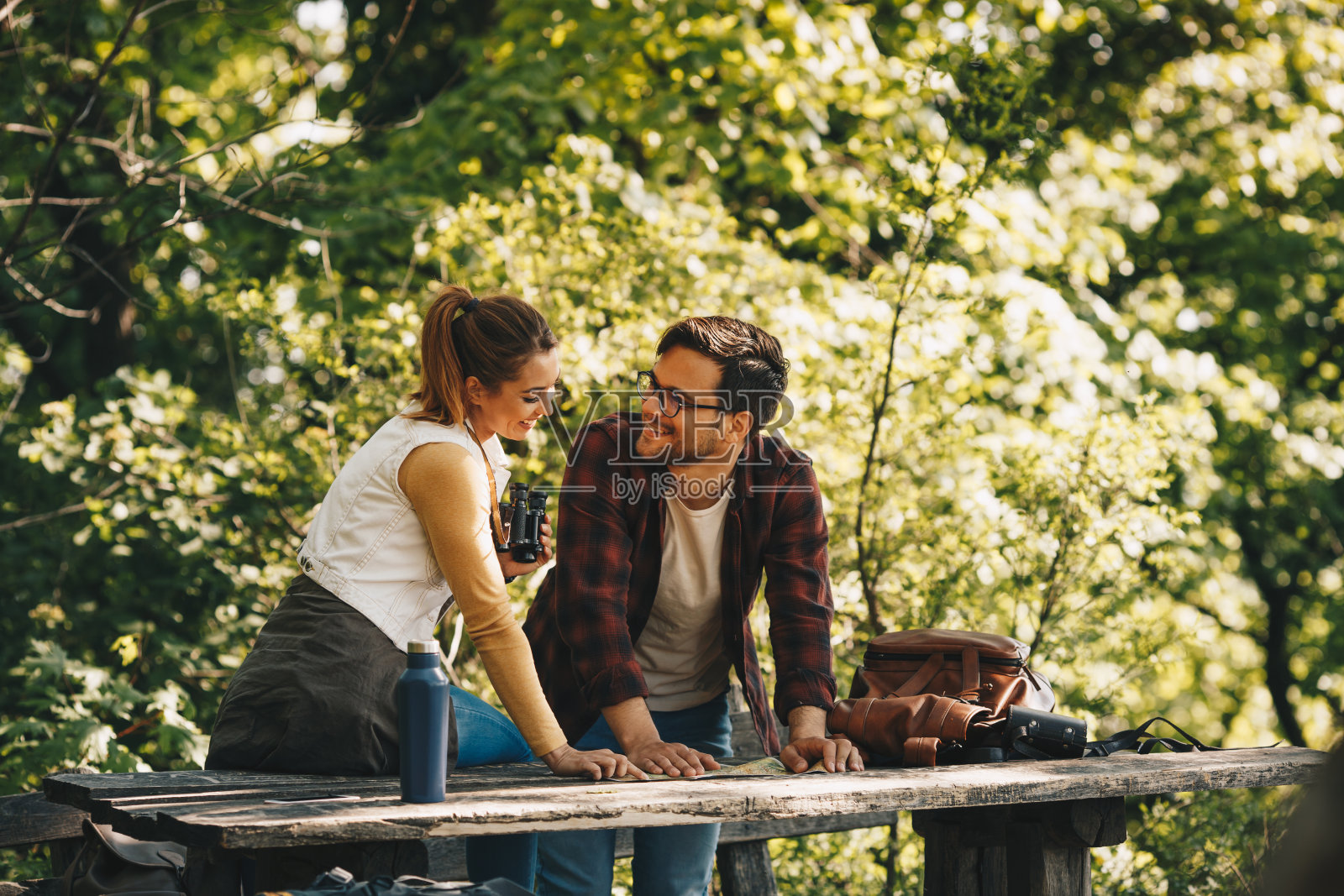 一对快乐的情侣微笑着穿过森林。照片摄影图片