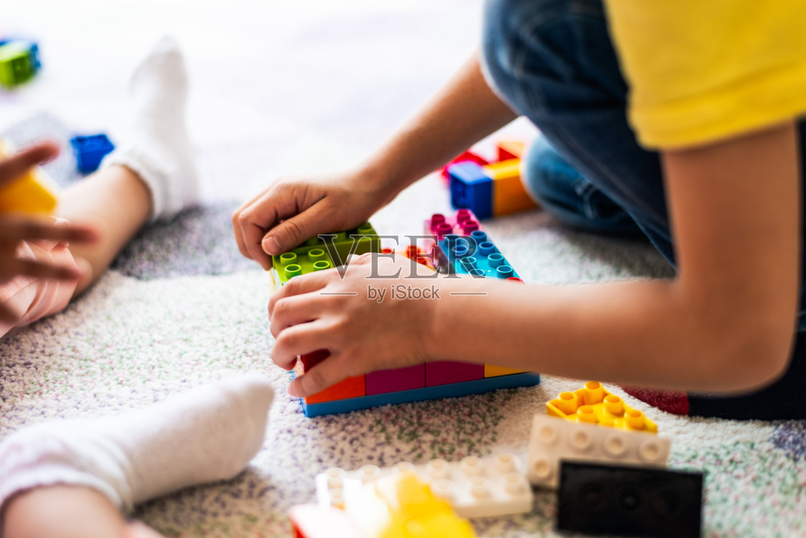 快乐的小朋友们玩着五颜六色的积木照片摄影图片