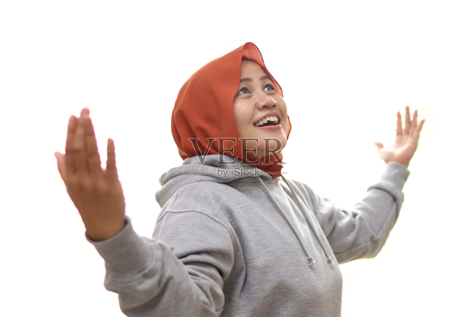 快乐的亚洲穆斯林妇女做出惊喜的获胜姿态,期待着来自上方的礼物照片摄影图片