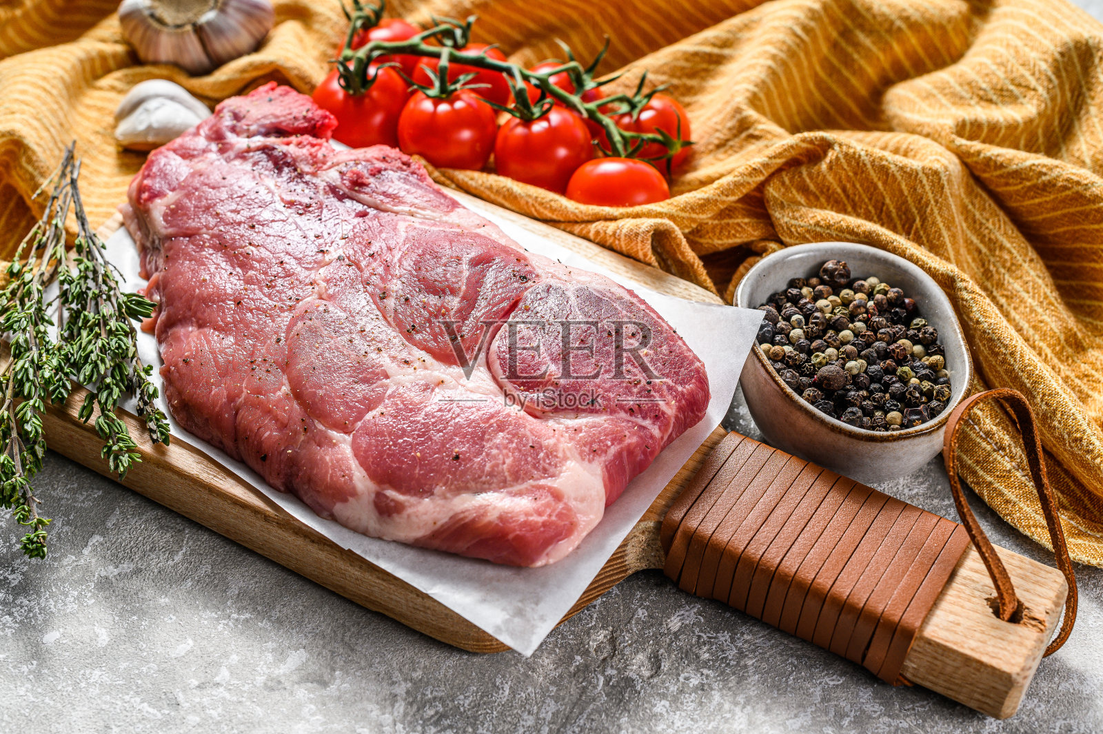 木砧板上的生大理石猪肉排。有机肉。灰色的背景。俯视图照片摄影图片