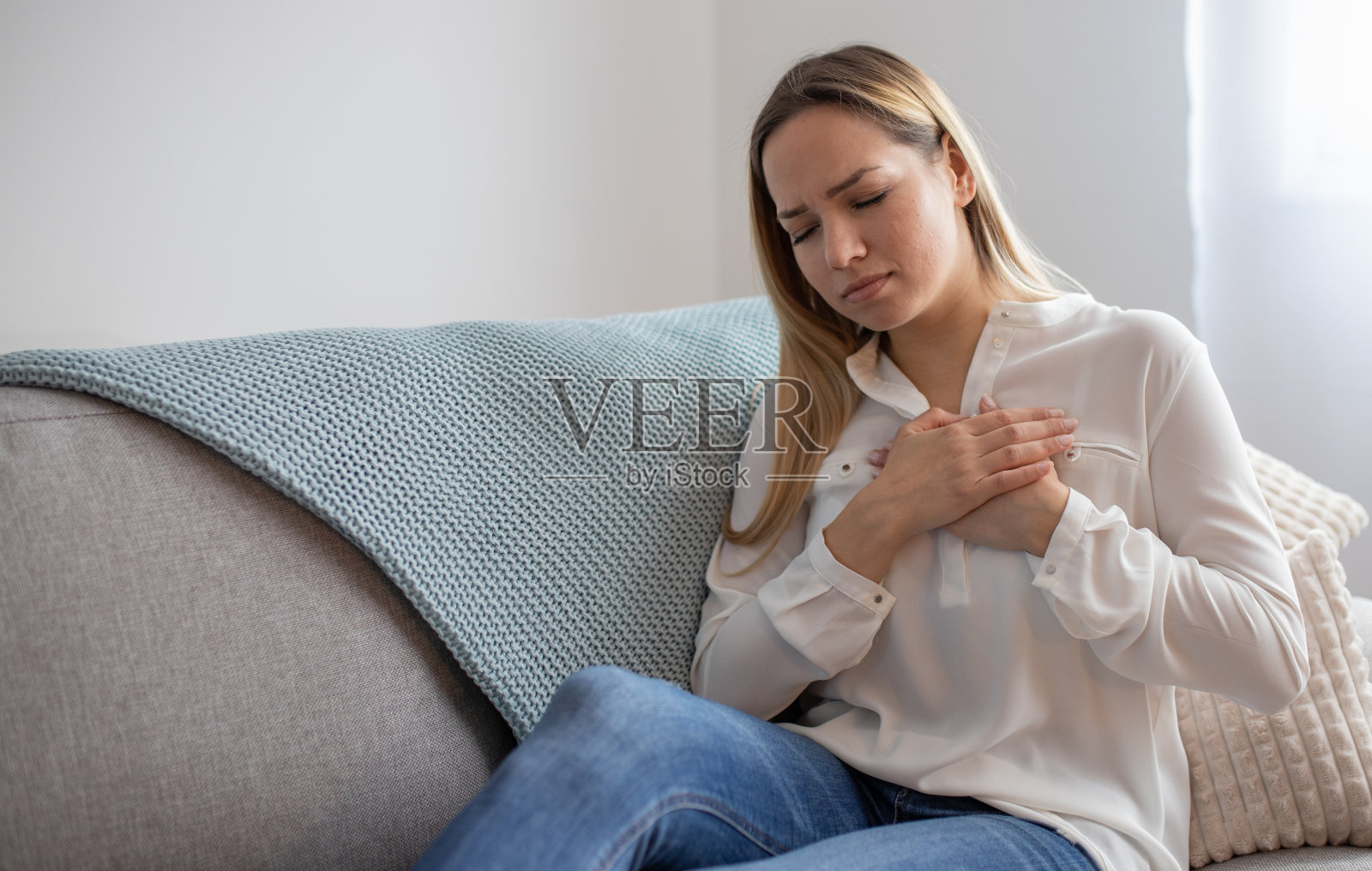 有个女人胸口疼。呼吸系统的疾病。有个女孩在家心脏病发作了。照片摄影图片