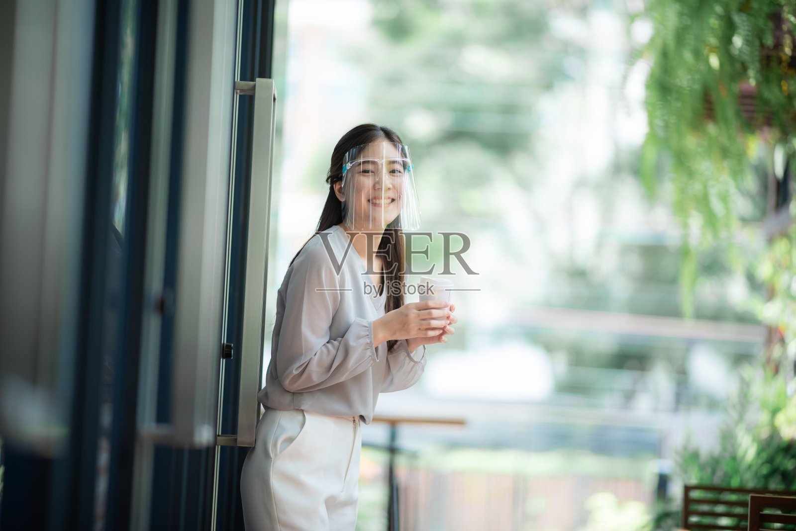 亚洲女性在咖啡厅戴口罩,既能预防传染性疾病,又能过上新的正常生活,预防新冠肺炎传染性疾病照片摄影图片