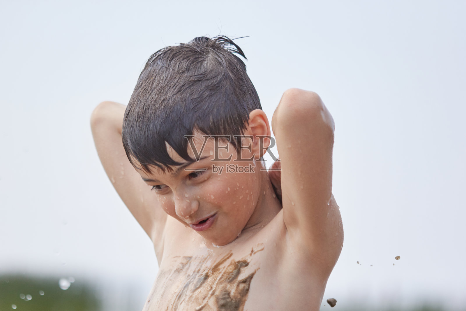 小孩子在水里洗澡,把脏东西抹在身上,然后高兴起来照片摄影图片