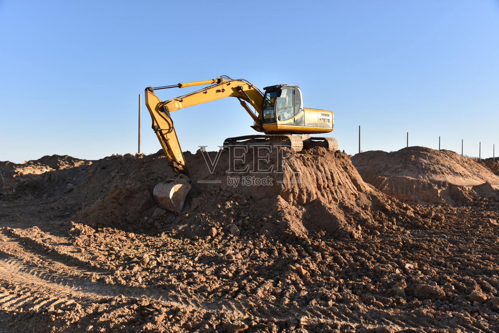 用挖掘机挖地基坑。土方工程中,挖掘和回填土壤至所需深度是建造沟槽所必需的照片摄影图片