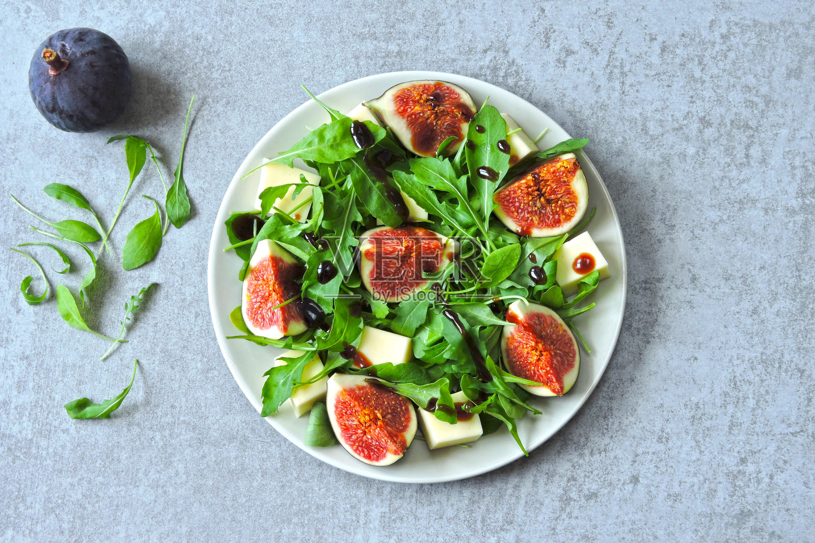 美味健康的无花果色拉配芝麻菜。照片摄影图片