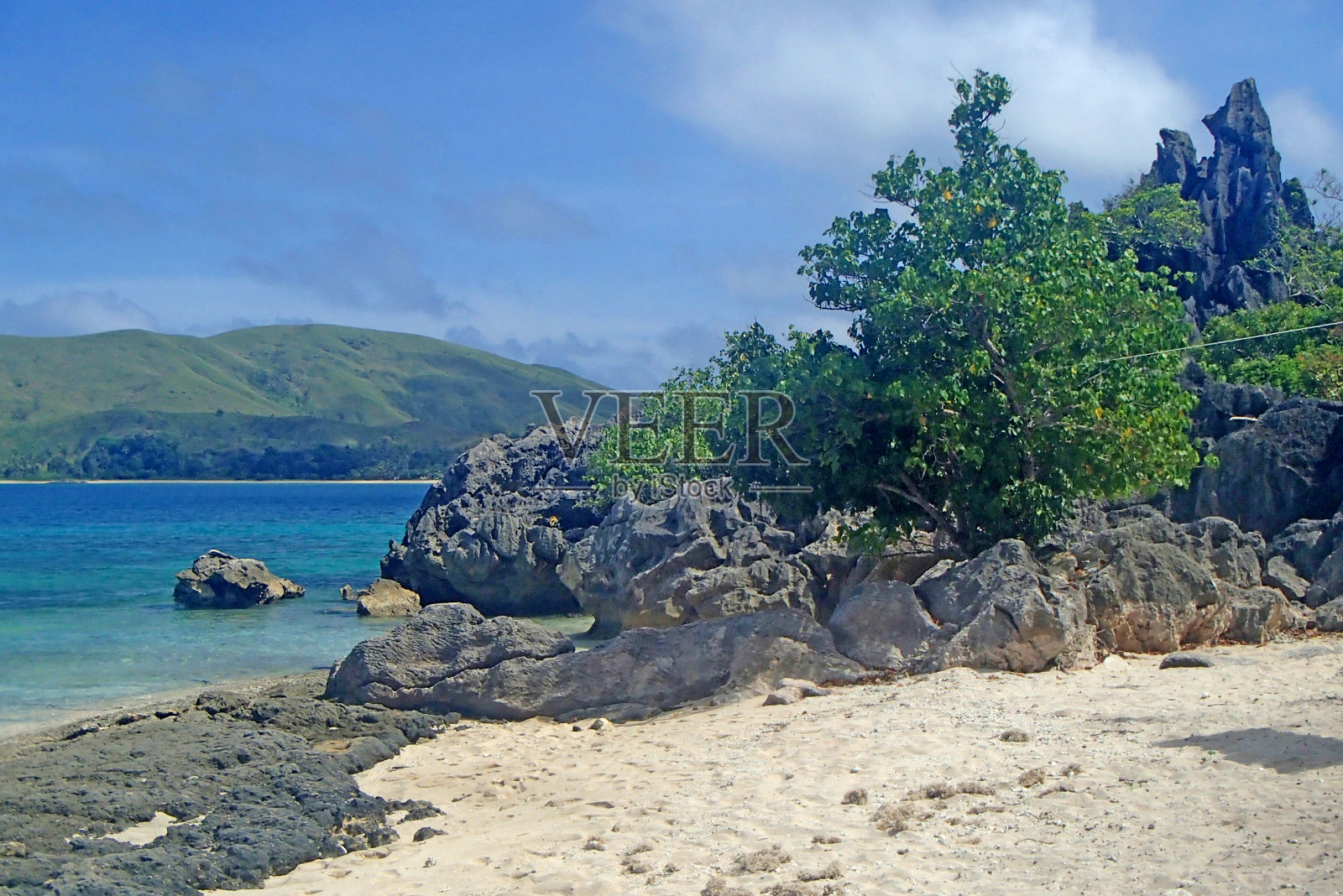 斐济的白色沙滩,岩石,绿松石的水和看到的山和姐妹岛照片摄影图片