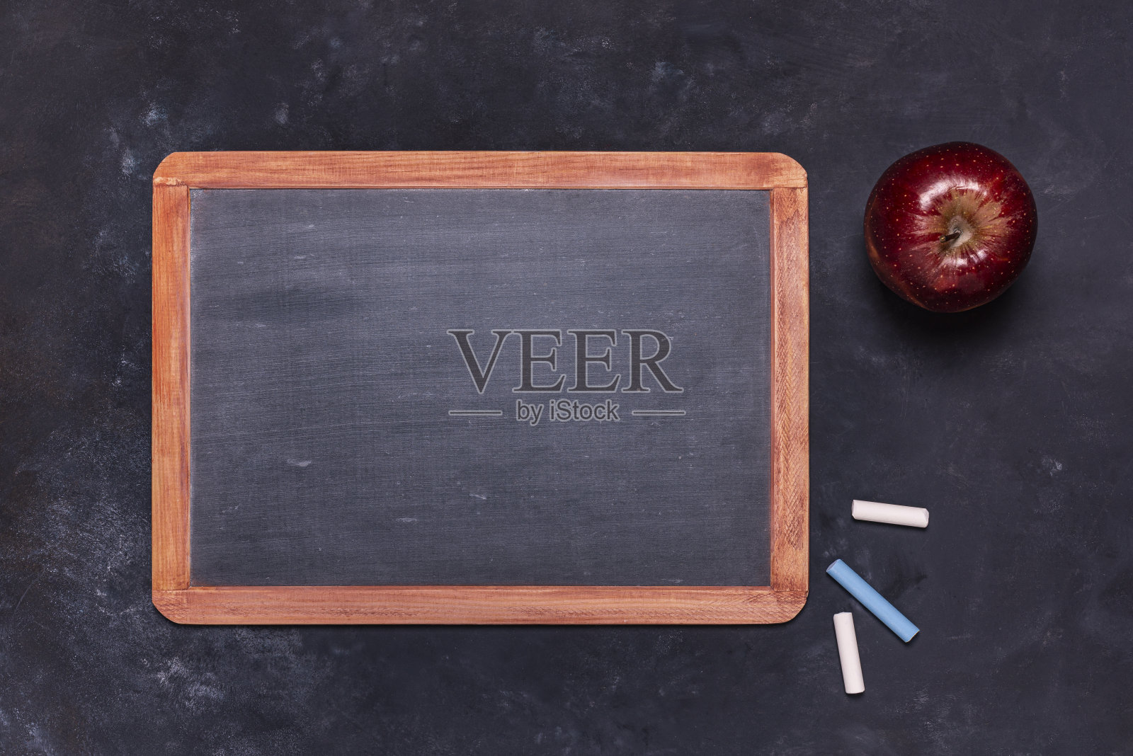 学校黑板上有粉笔和红苹果。照片摄影图片