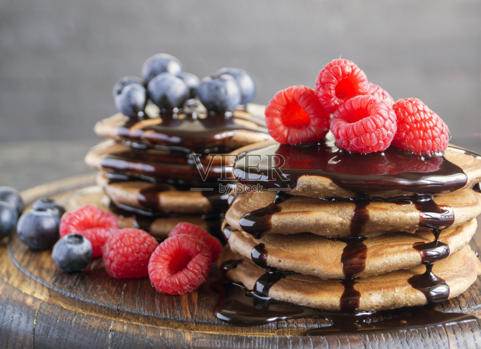 黑色背景上有覆盆子的巧克力煎饼。照片摄影图片