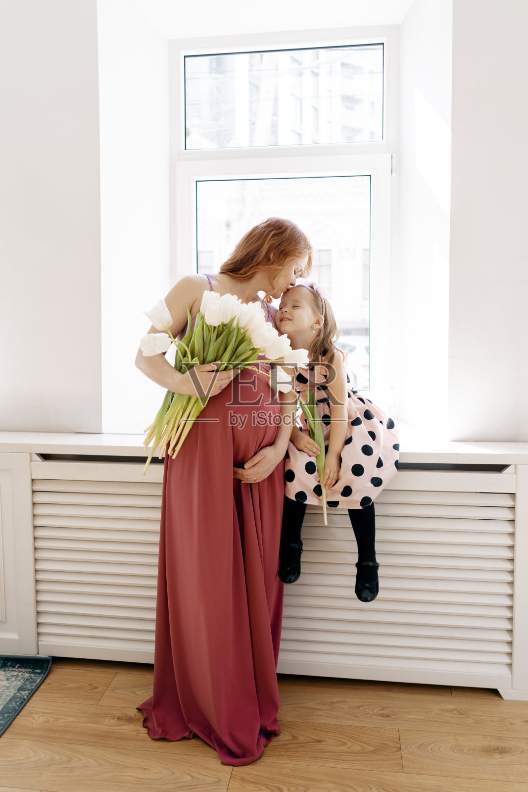 肖像孕妇与她的女儿和白色郁金香照片摄影图片