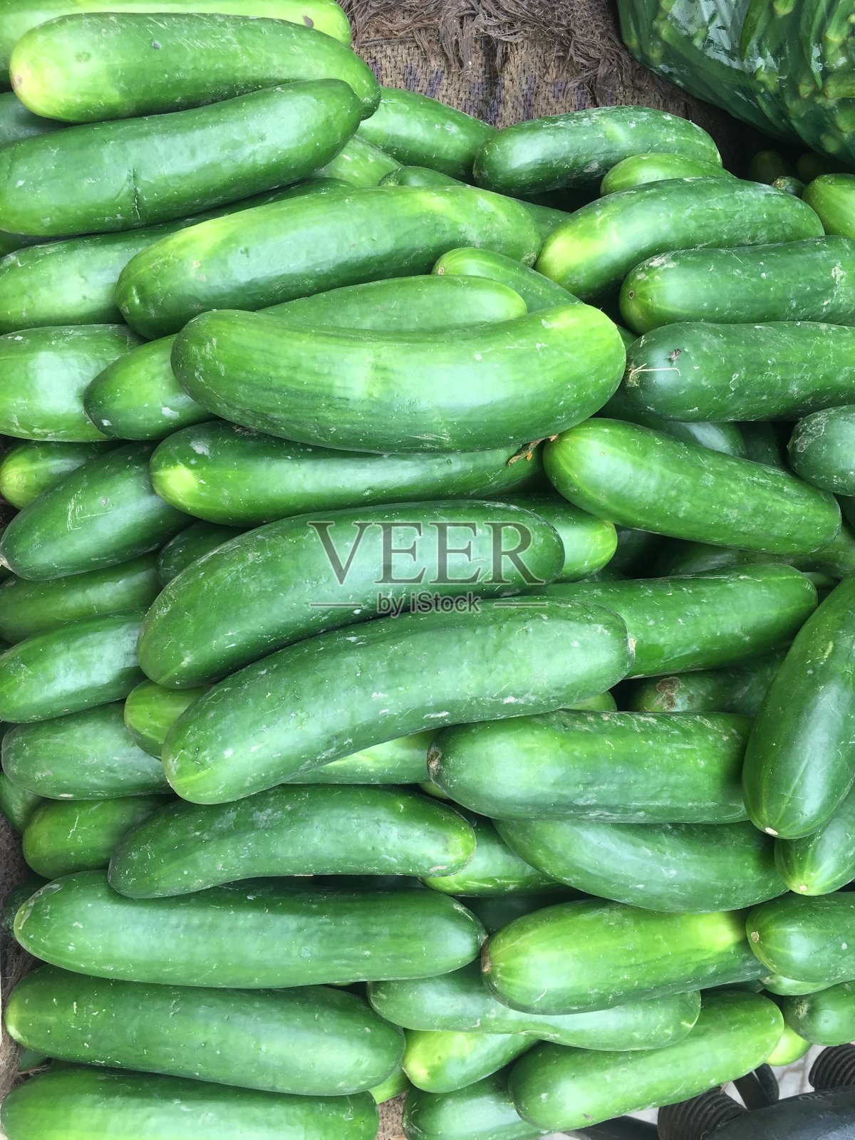 地上有黄瓜可以吃的蔬菜。市面上出售的绿黄瓜及新鲜水果。照片摄影图片