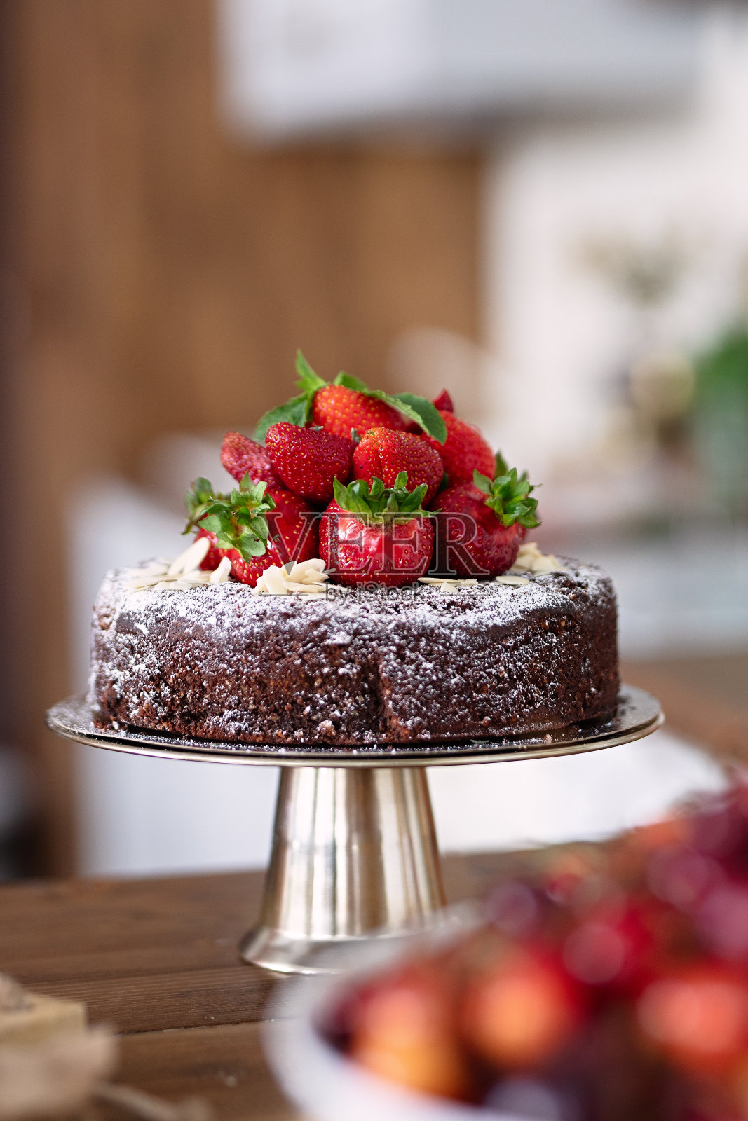 巧克力蛋糕上点缀着浆果、草莓躺在甜点上,甜甜的躺在金属盘上,选择性聚焦照片摄影图片