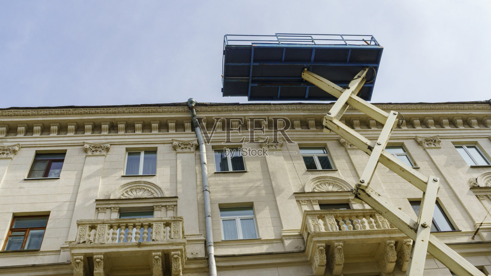 剪刀机械电梯对背景的一个翻新公寓大楼。维修的概念。照片摄影图片