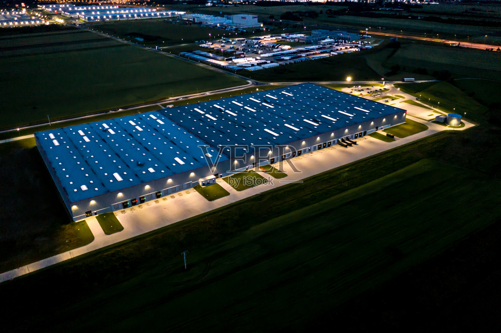 货物仓库夜景鸟瞰图。物流中心位于工业城区上空。物流中心卡车装车鸟瞰图。从无人机。照片摄影图片