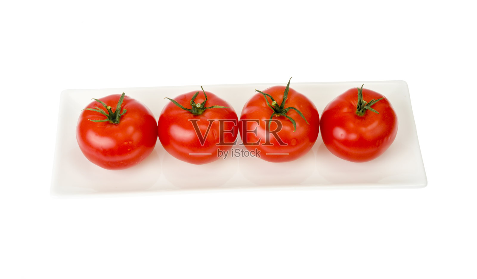 白色盘子里放着四个成熟的红番茄。照片摄影图片