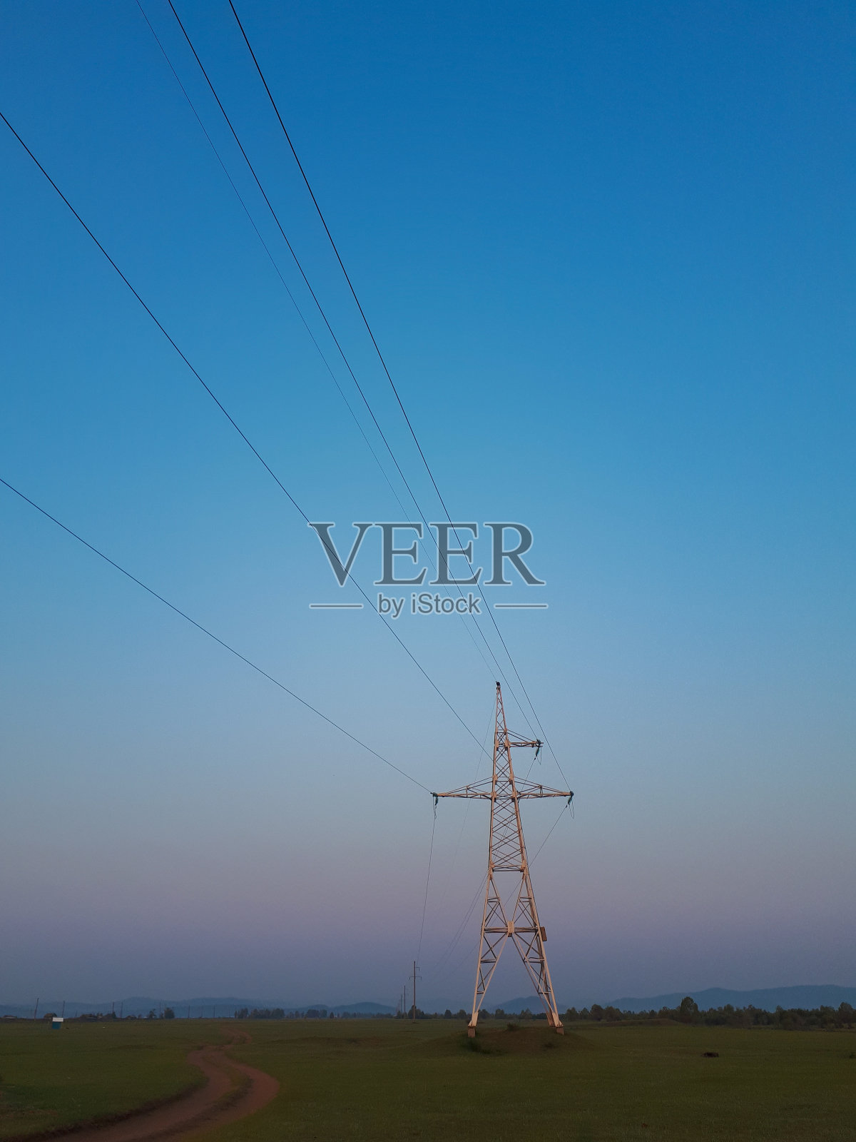 照片中的金属电力线在阳光下呈几何图形,天空是黎明的蓝色照片摄影图片