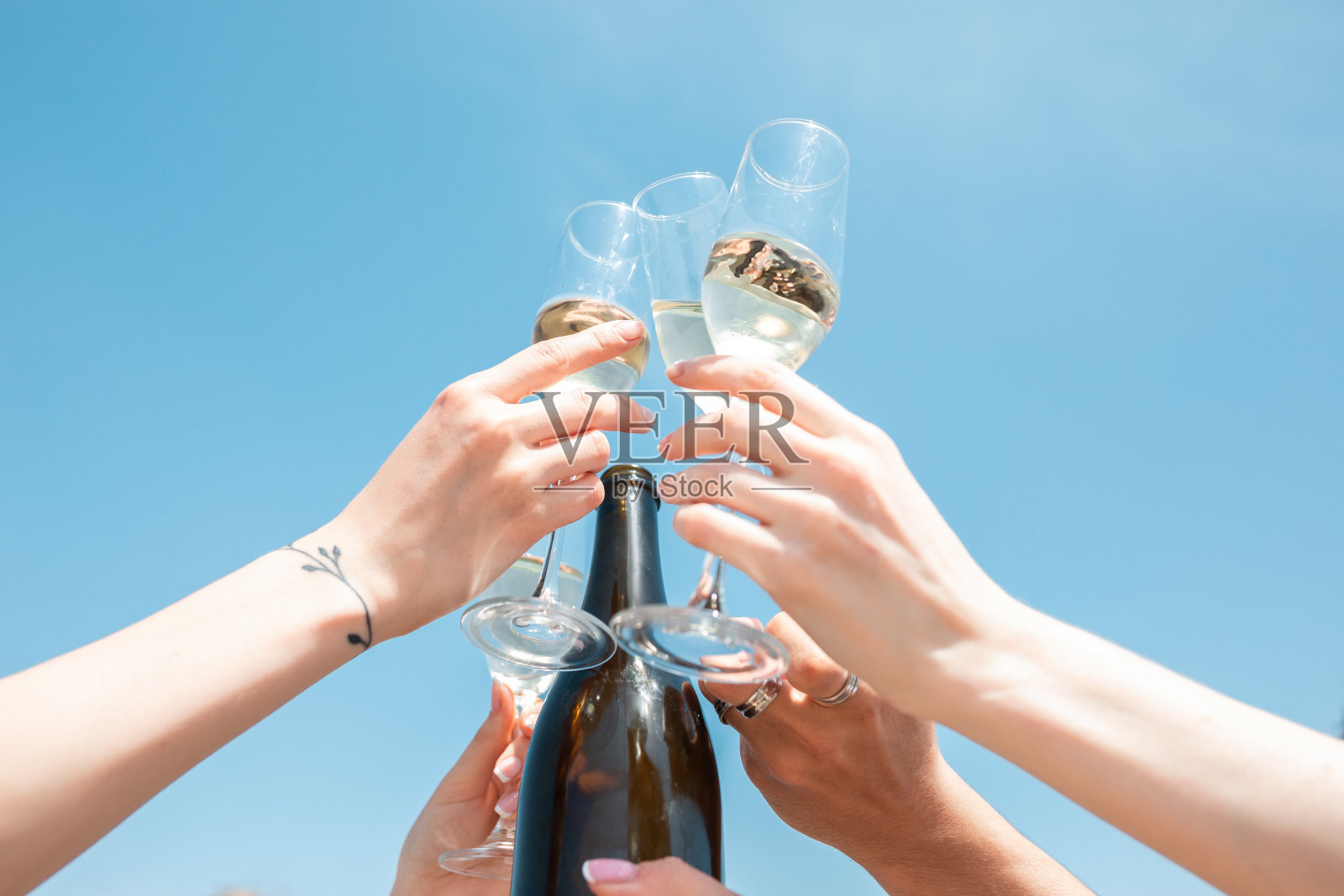 海滩度假胜地的季节性盛宴。在天空的背景下,朋友们一起庆祝、休息、玩乐、碰杯照片摄影图片