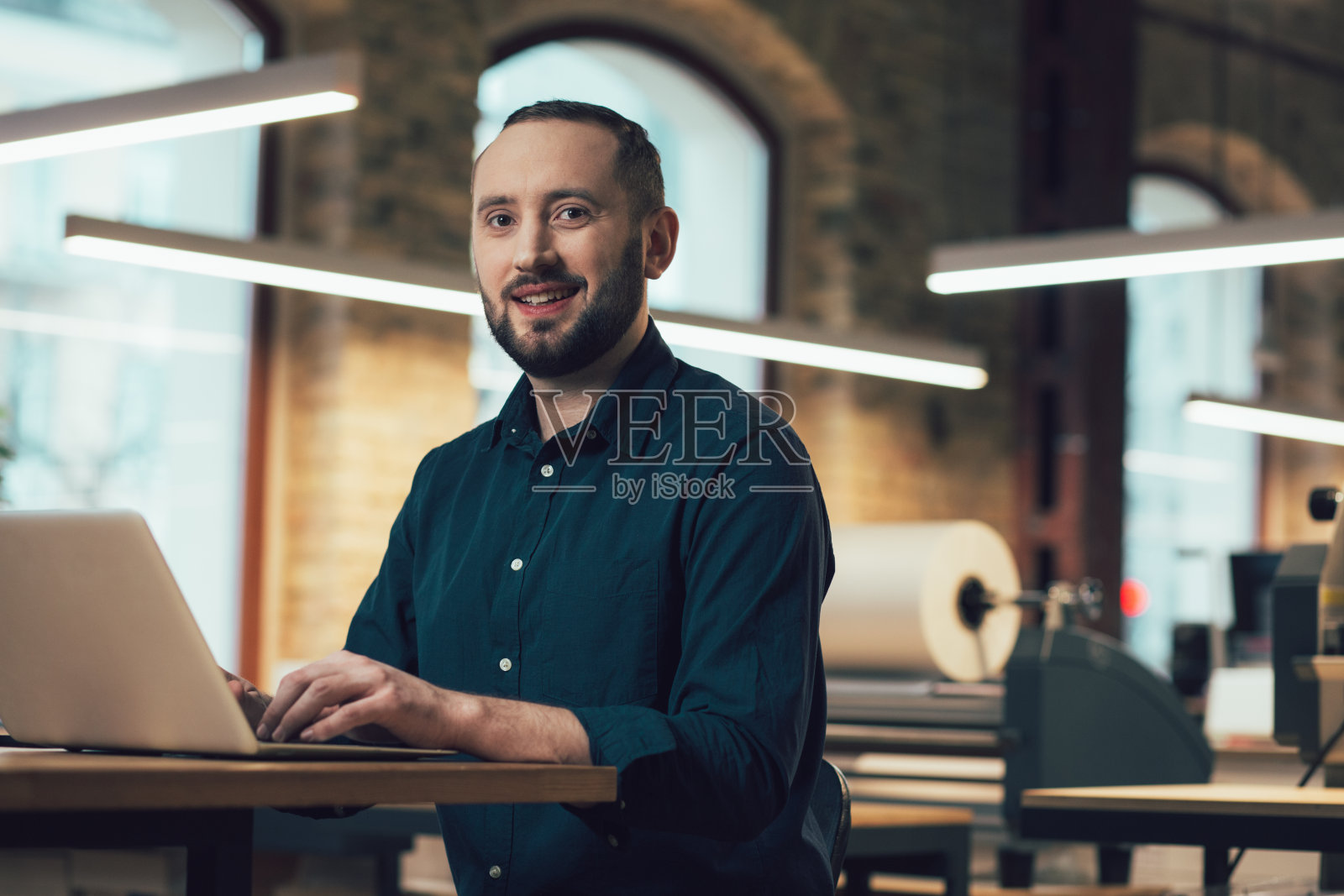 自信的员工坐在他的办公室里微笑着照片摄影图片