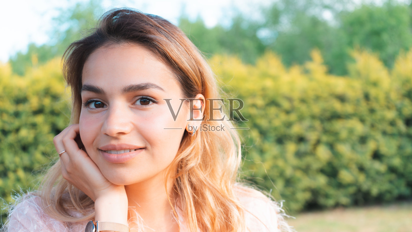 英俊的女人看着相机微笑肖像拍摄。美丽和快乐的混血女孩在一个阳光明媚的日子户外照片摄影图片