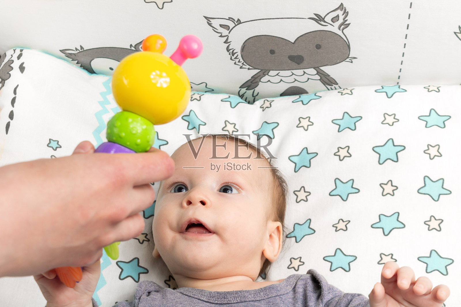 一个快乐上进的小孩首先玩的是摇铃,新生儿的玩具照片摄影图片