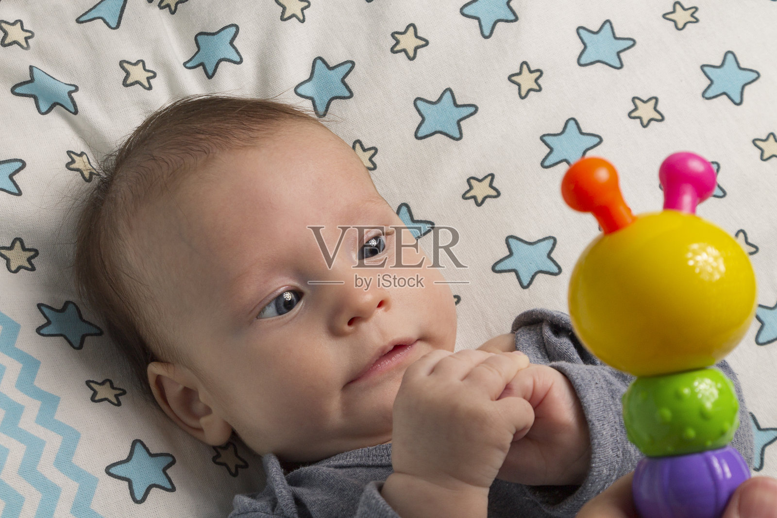 一个快乐上进的小孩首先玩的是摇铃,新生儿的玩具照片摄影图片