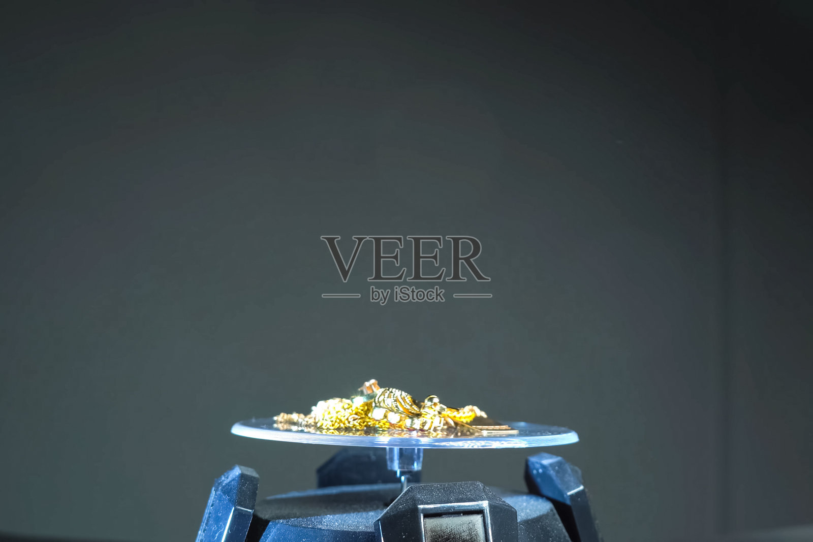 电子秤上的旧金首饰。照片摄影图片