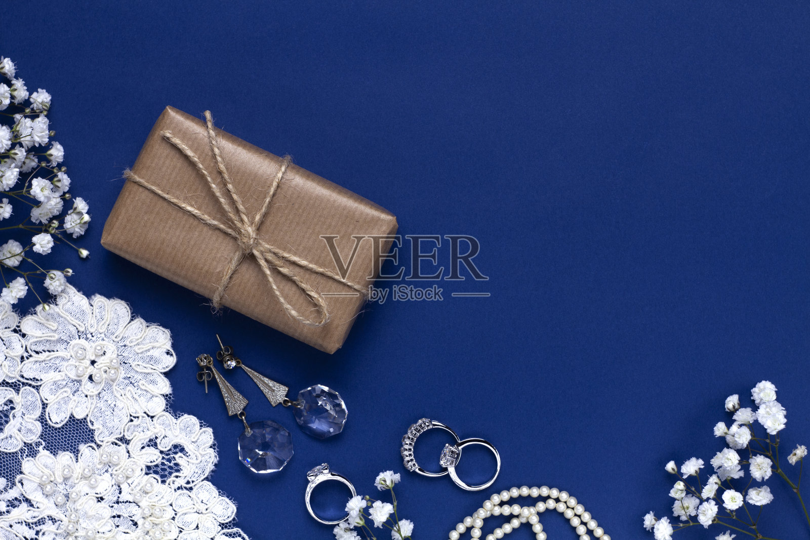 吉普赛花,花边,珠宝,礼盒上美丽的蓝色背景。用于婚礼设计,邀请,问候。平躺,俯视图。照片摄影图片