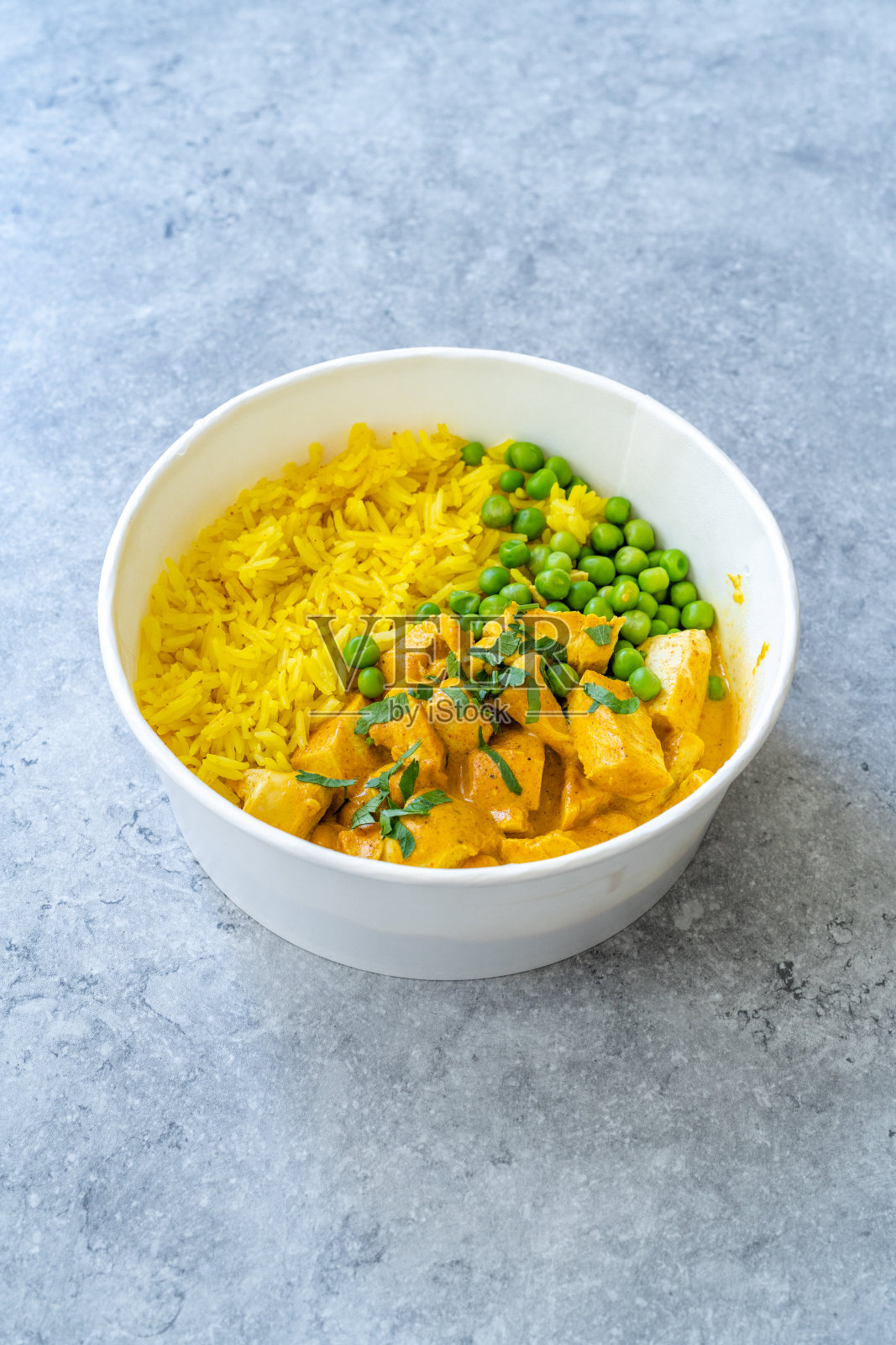 外卖印度街头小吃Tikka Masala配鸡肉,咖喱巴斯马蒂米饭,绿豌豆和椰奶酱。照片摄影图片