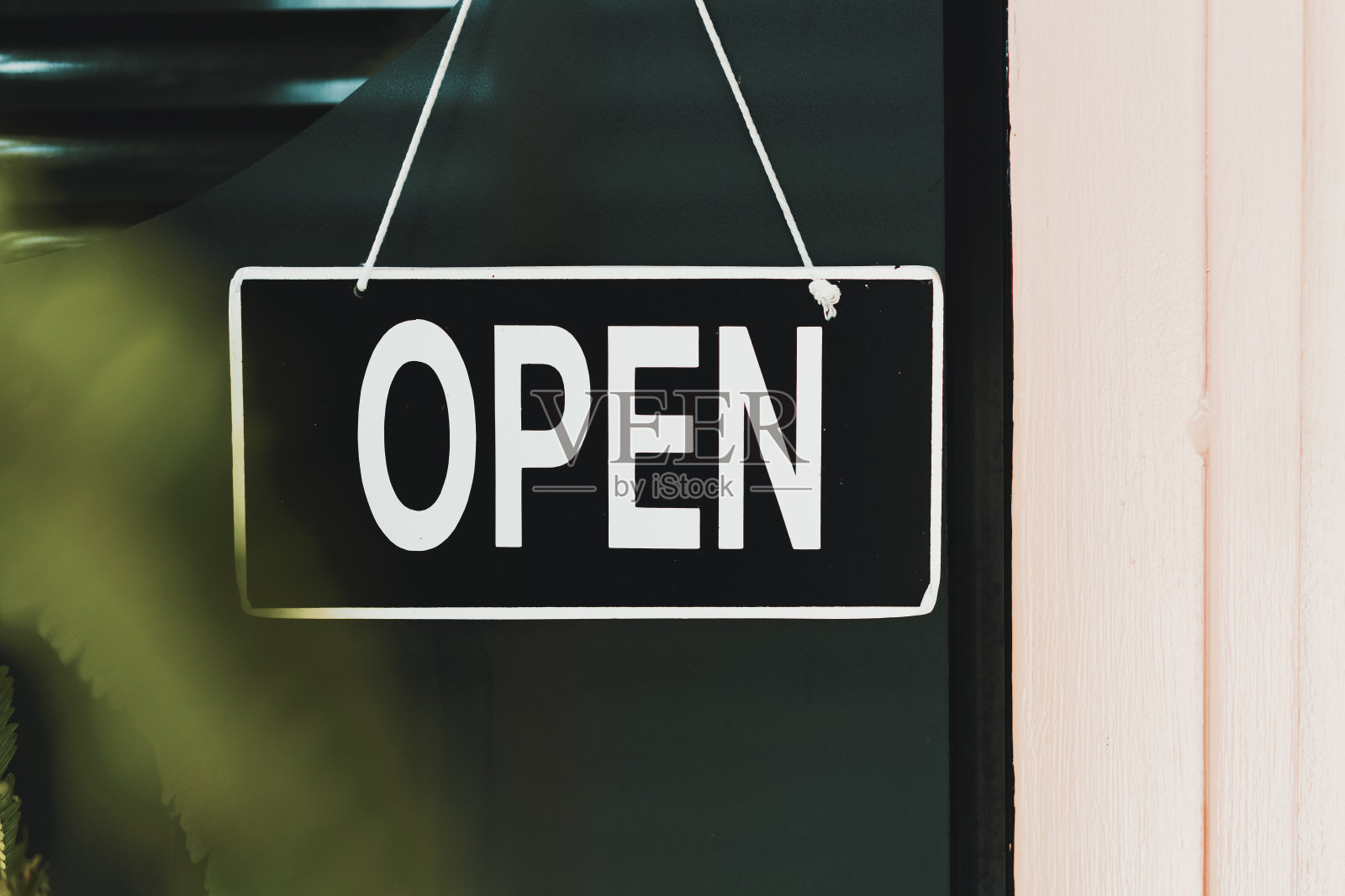 咖啡馆门前的木门上挂着开阔的招牌。经营服务和餐饮理念。照片摄影图片